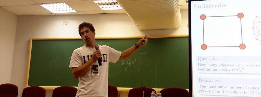 Instructor standing at front of classroom explaining something on screen.